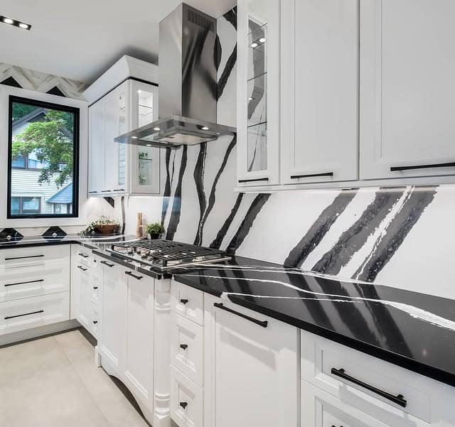 17. White Kitchen with Bold Black Veined Marble Countertops - white and black kitchen ideas