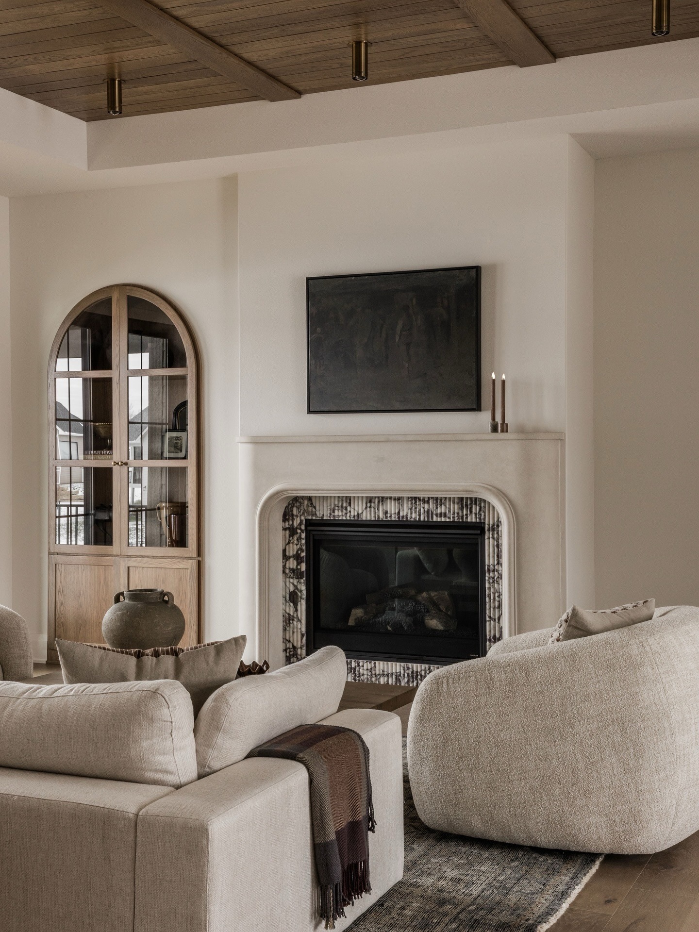 11. Soft Neutral Living Room with Arched Fireplace and Warm Wood Ceiling - living room ideas with fireplace