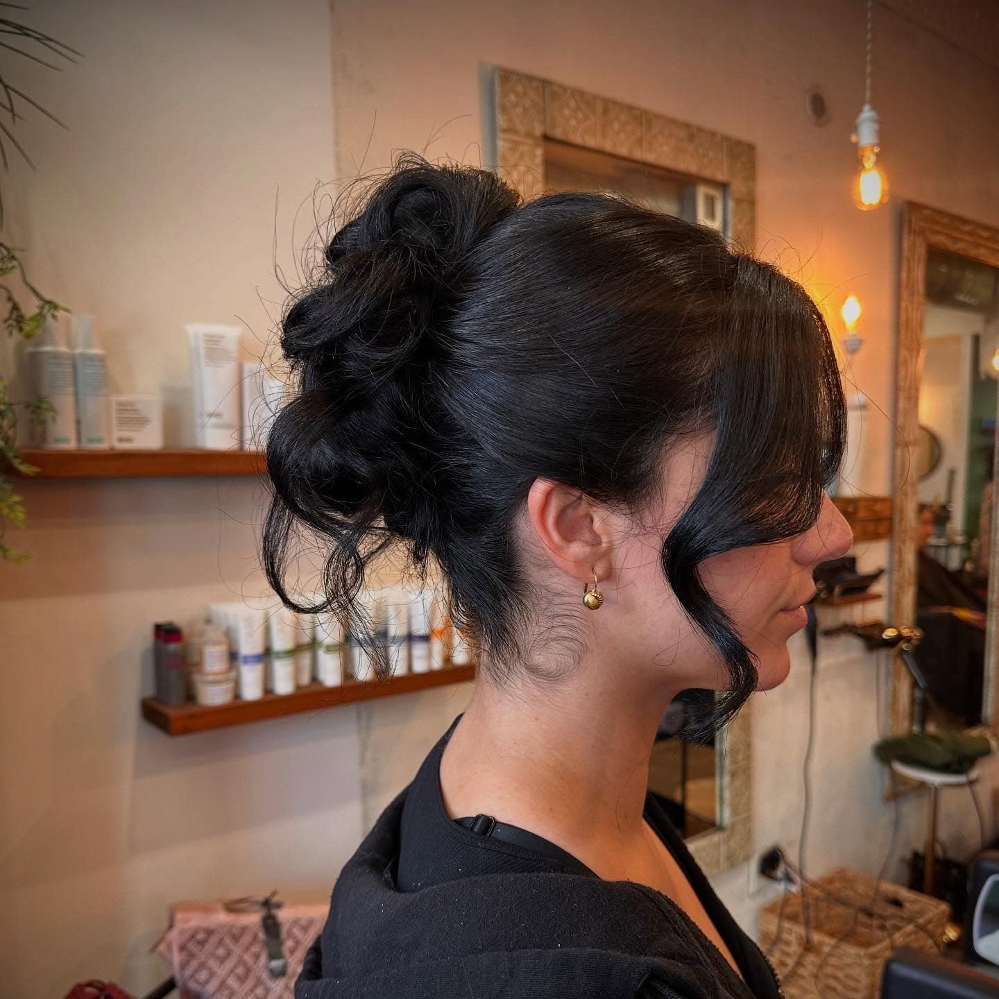 7. Voluminous Black Textured Updo with Loose Tendrils - Updo Hairstyles