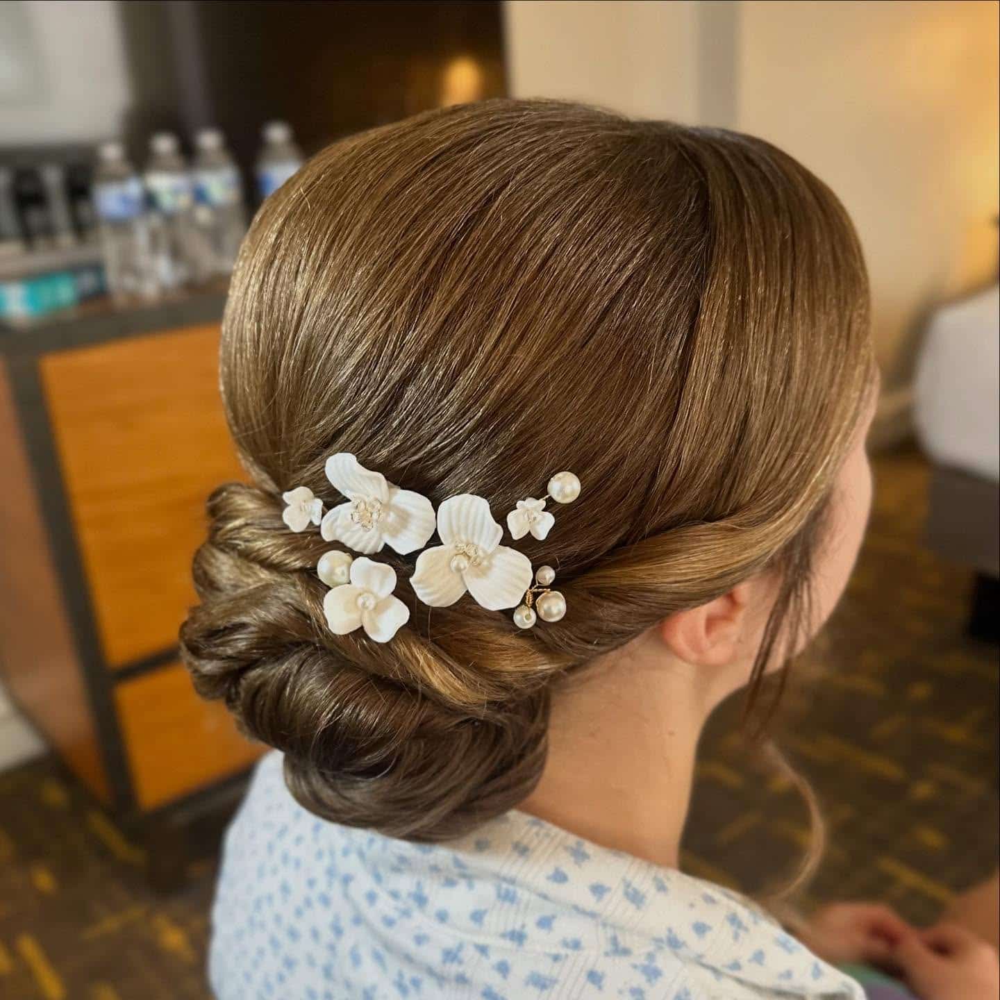 15. Sleek Brunette Low Bun with Floral Hairpiece - Updo Hairstyles