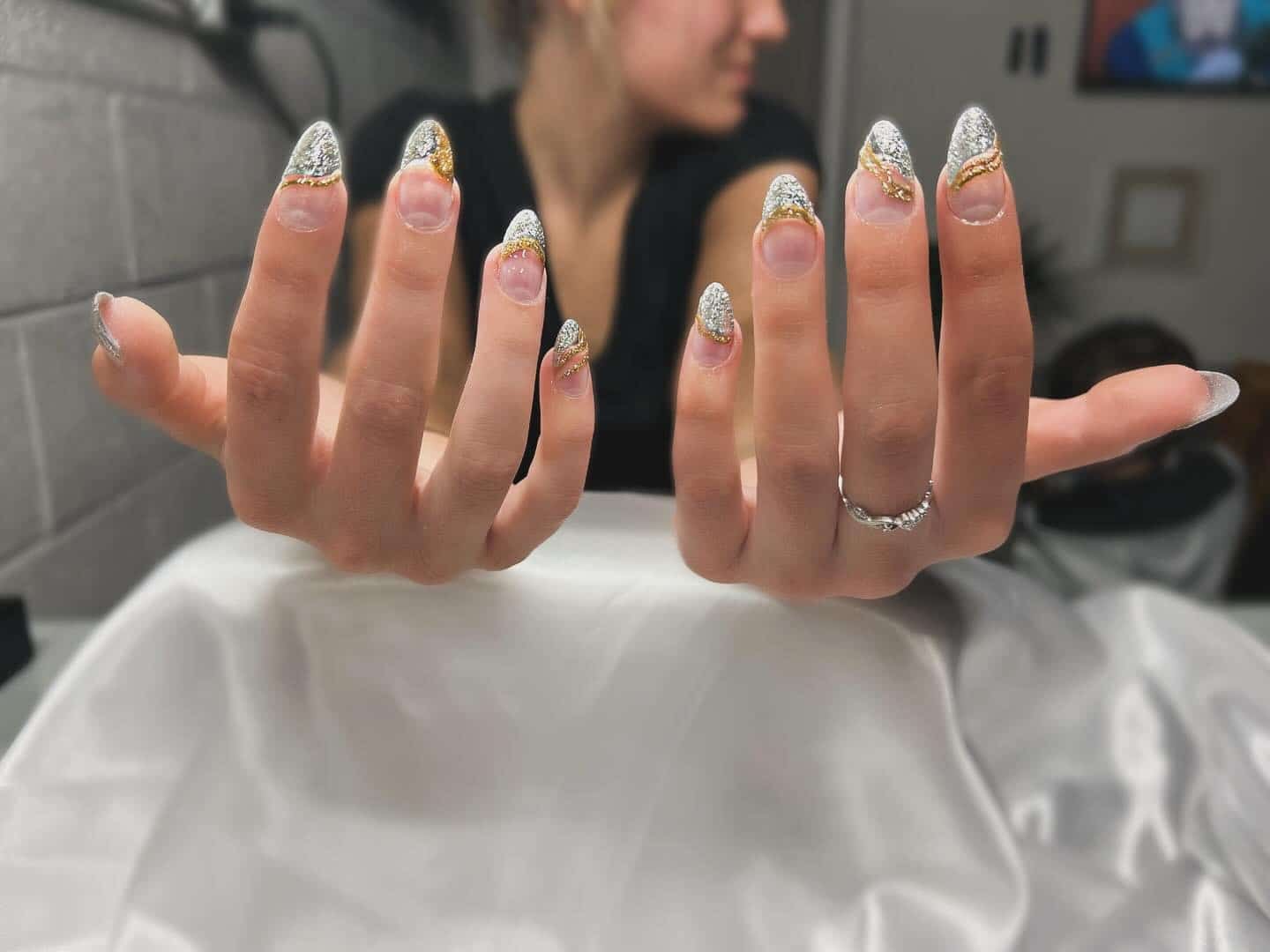 1. Silver Glitter French Tips with Gold Wave Accents - silver and gold nail ideas