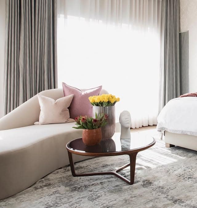 22. Soft Neutral Bedroom with Curved Sofa Lounge and Blush Accents - sofa in bedroom ideas