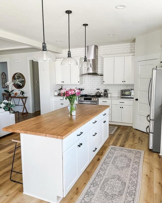 21. White Island with Butcher Block Top and Glass Pendants - farmhouse kitchen island ideas
