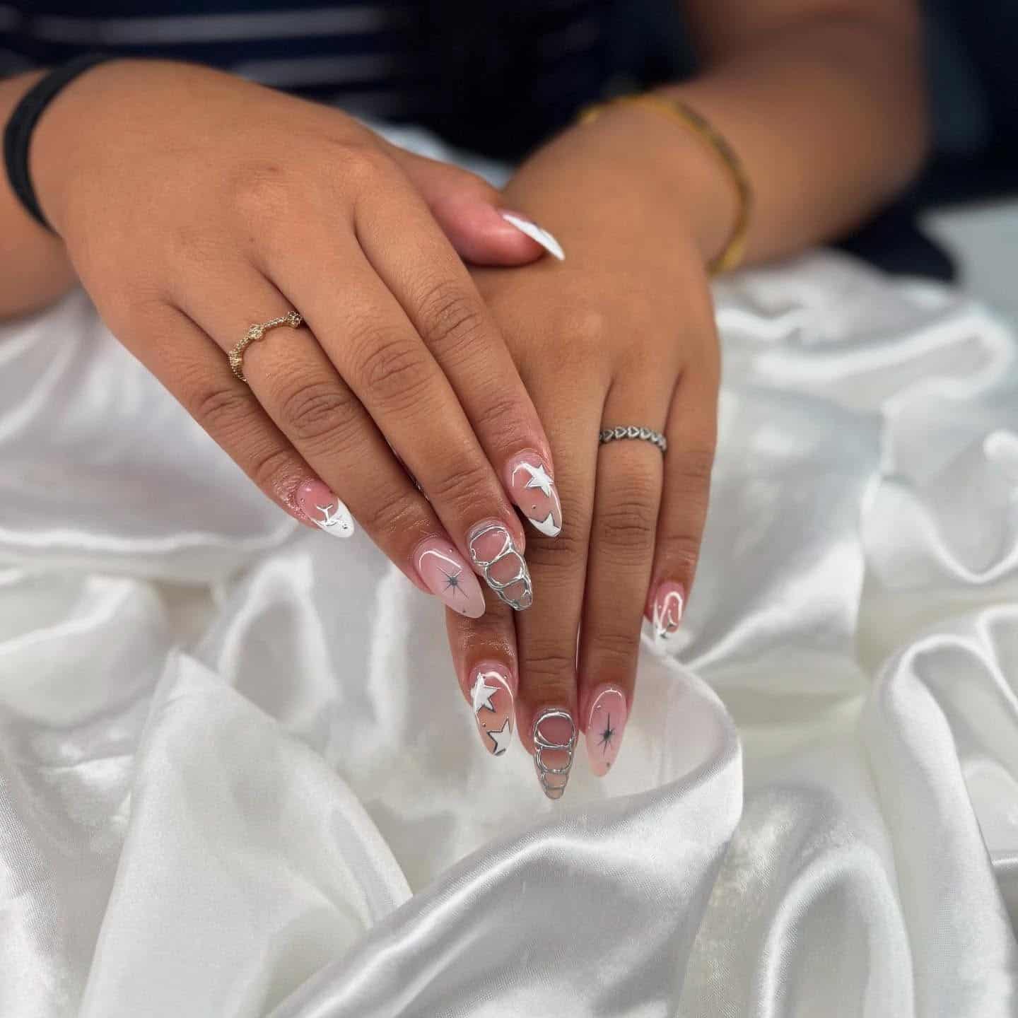 4. Nude and White Star Accent Nails with Chrome Details - silver and white nail ideas