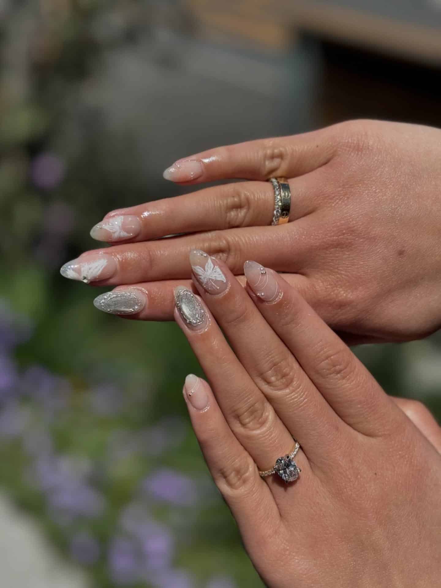 21. Nude and White Floral Almond Nails with Silver Chrome Accent - silver and white nail ideas