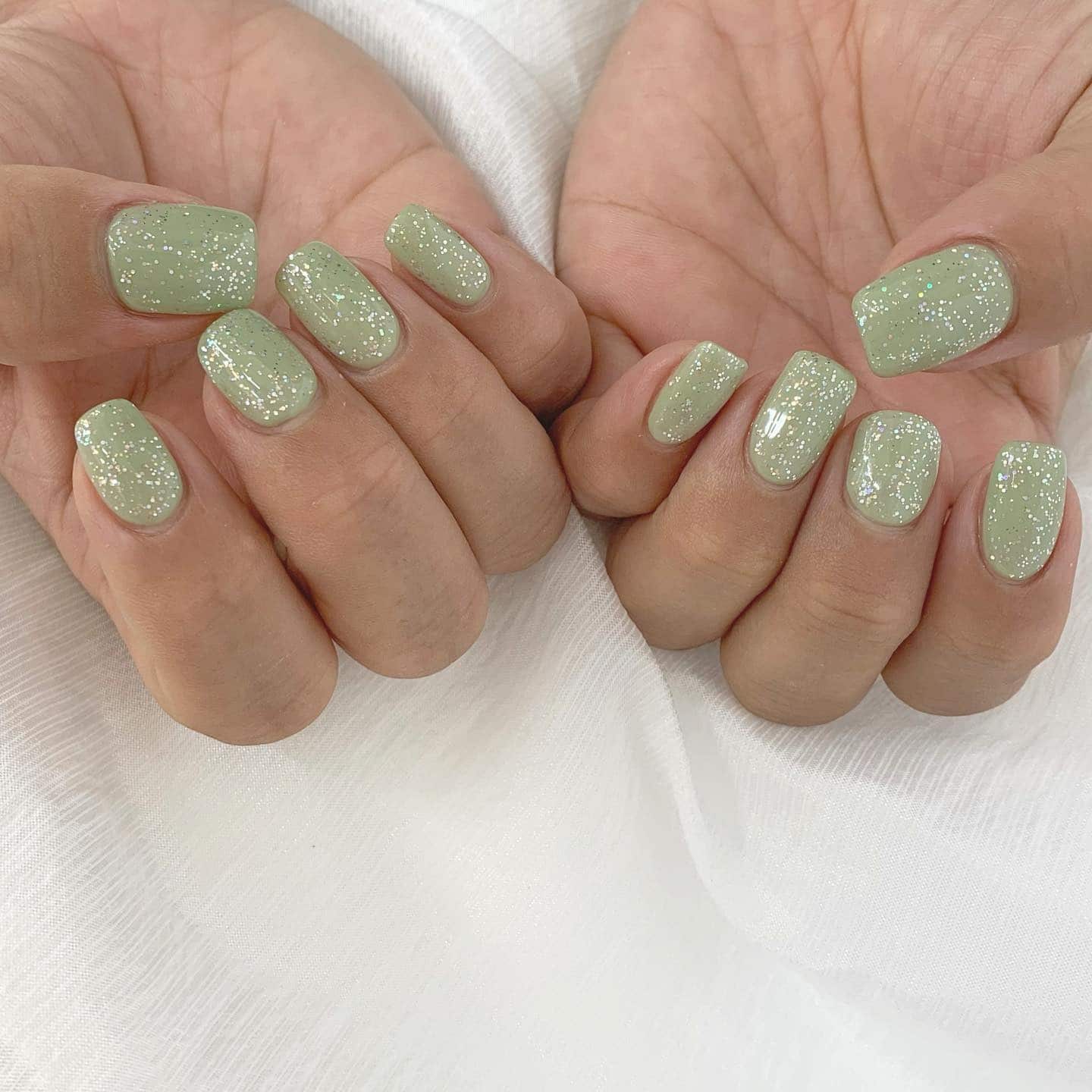 1. Soft Sage Glitter Short Square Nails - simple green nail ideas