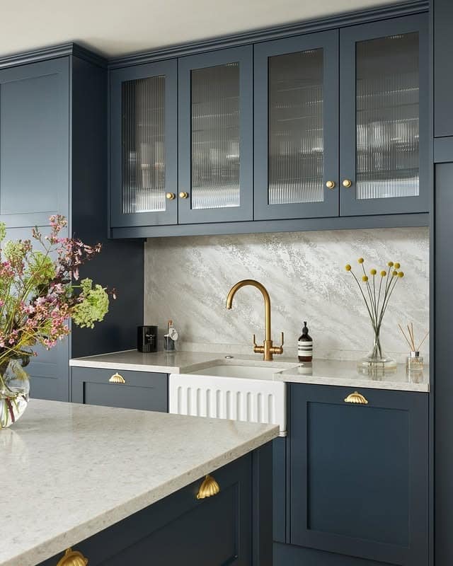 15. Dusty Blue Kitchen with Fluted Glass Cabinets and Brass Accents - blue kitchen ideas