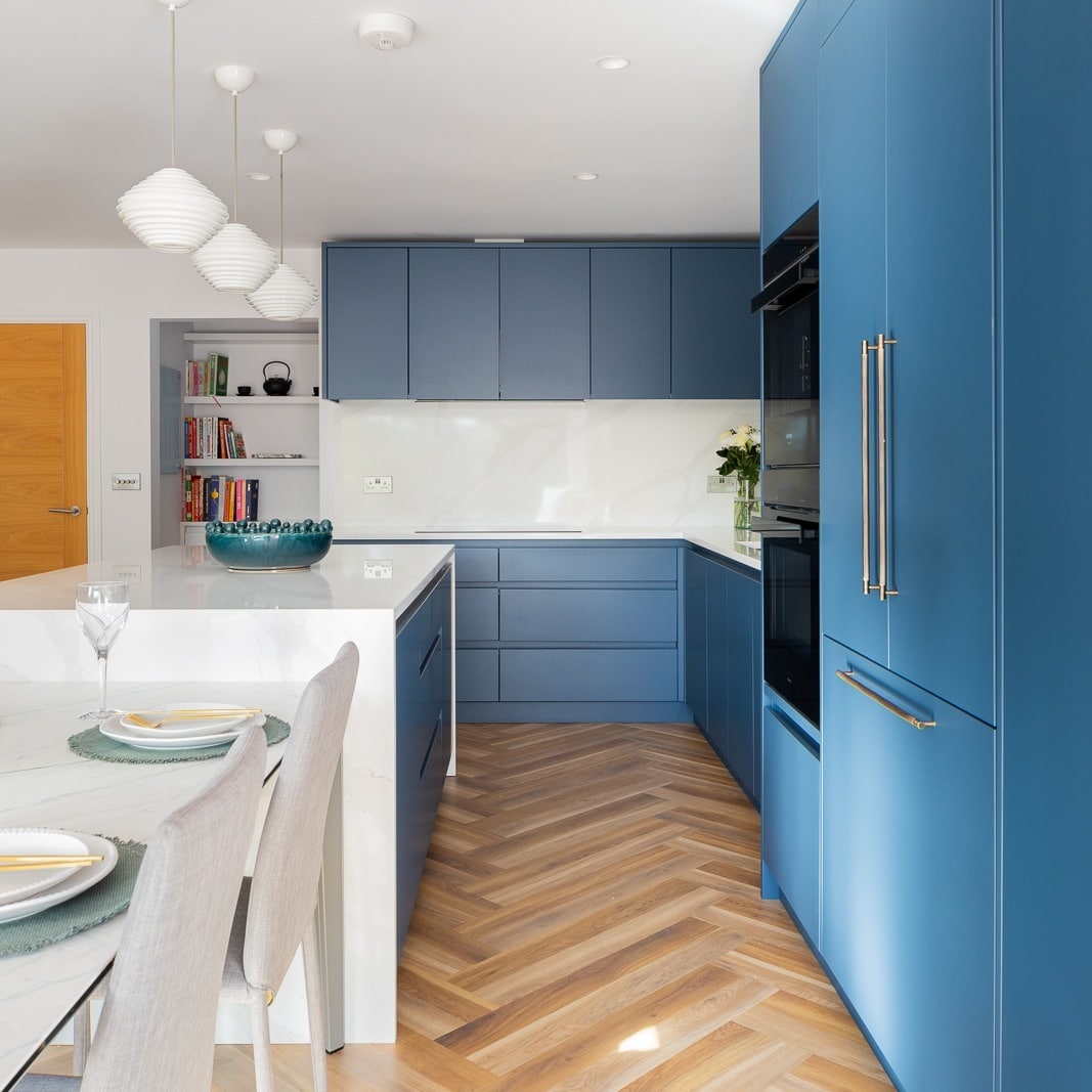 17. Modern Blue Kitchen with Handleless Cabinets and Wood Flooring - blue kitchen ideas