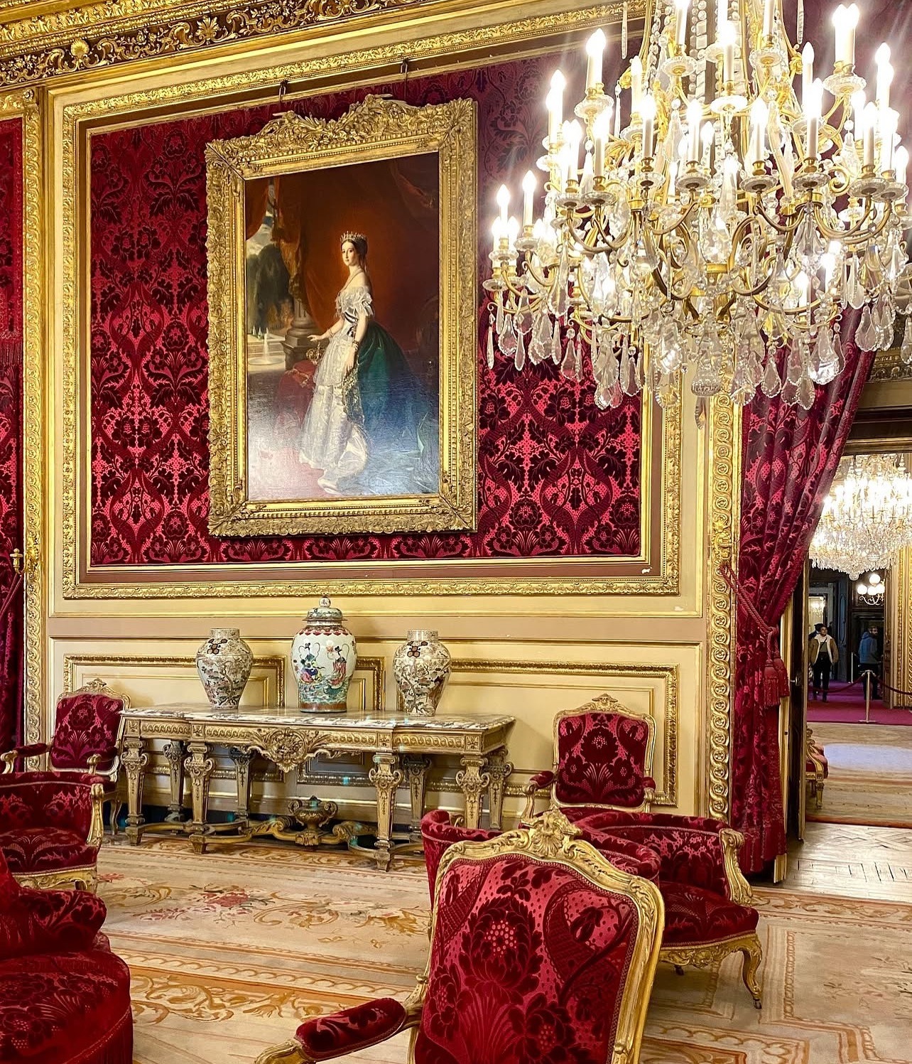 11. Opulent Crimson and Gold Salon with Classic European Influence - red living room ideas
