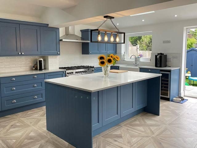 5. Muted Blue Cabinetry with Light Gray Flooring Contrast - blue and gray kitchen ideas