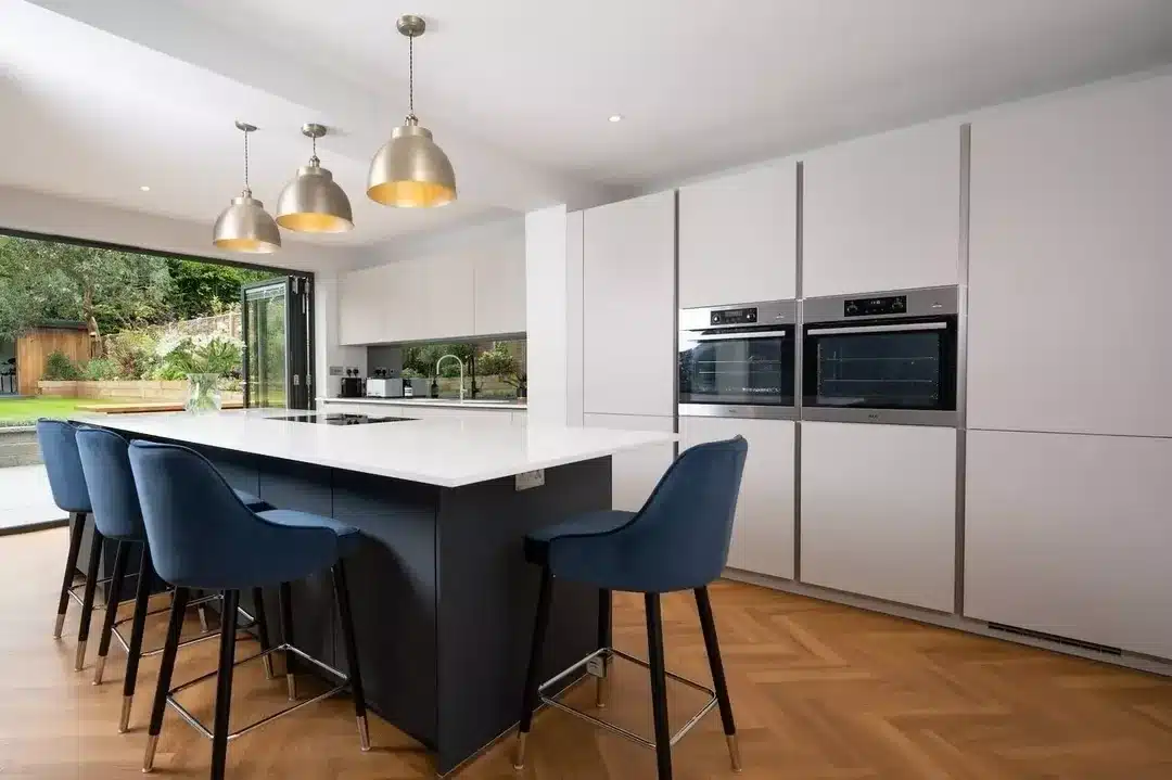 8. Dark Blue Island with Soft Gray Surround and Warm Lighting - blue and gray kitchen ideas