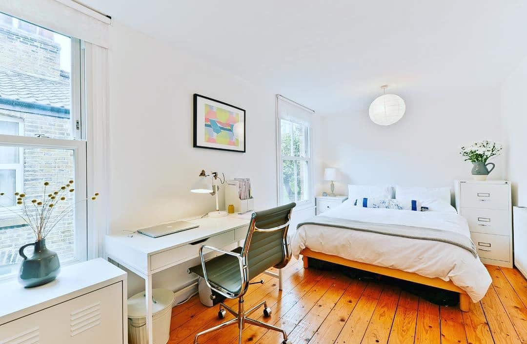 18. Bright White Bedroom Office with Warm Wood Flooring - bedroom office ideas
