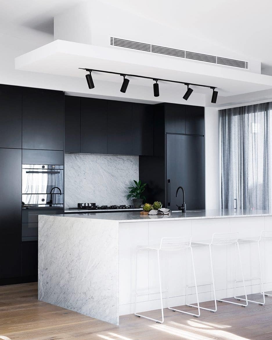 5. Minimalist Kitchen with Matte Black Cabinets and White Stone - black and white kitchen ideas