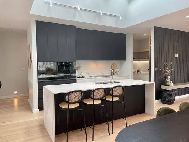 11. Modern Open-Concept Kitchen with Black Slab Cabinets and White Island - black and white kitchen ideas
