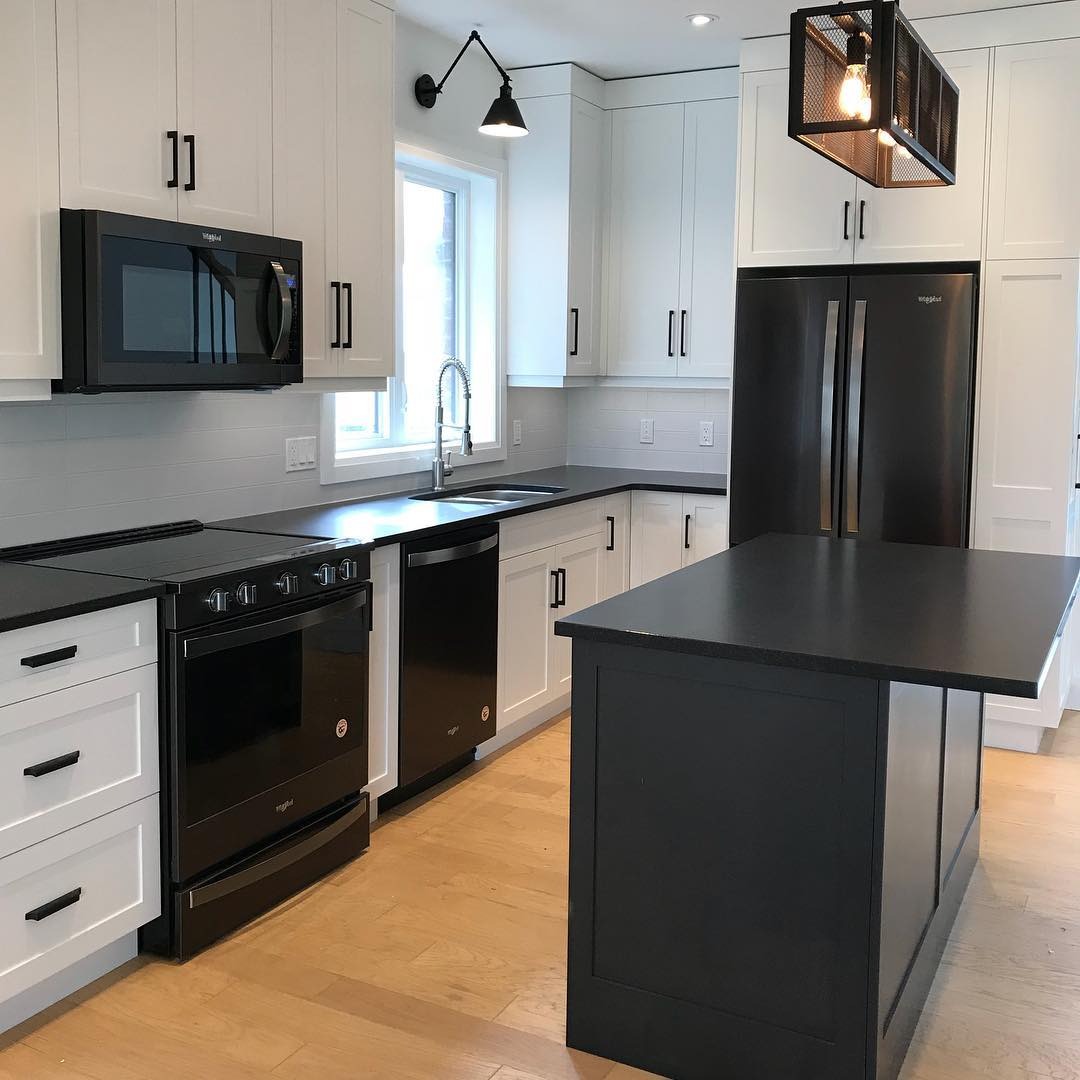 12. Classic White Kitchen with Black Island and Industrial Lighting - black and white kitchen ideas