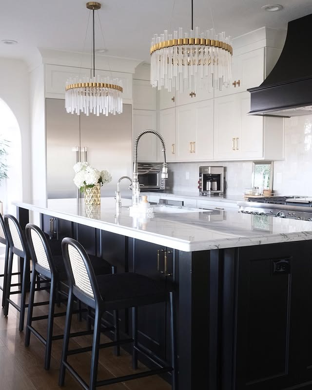18. Luxe White Kitchen with Black Island and Crystal Lighting - black and white kitchen ideas