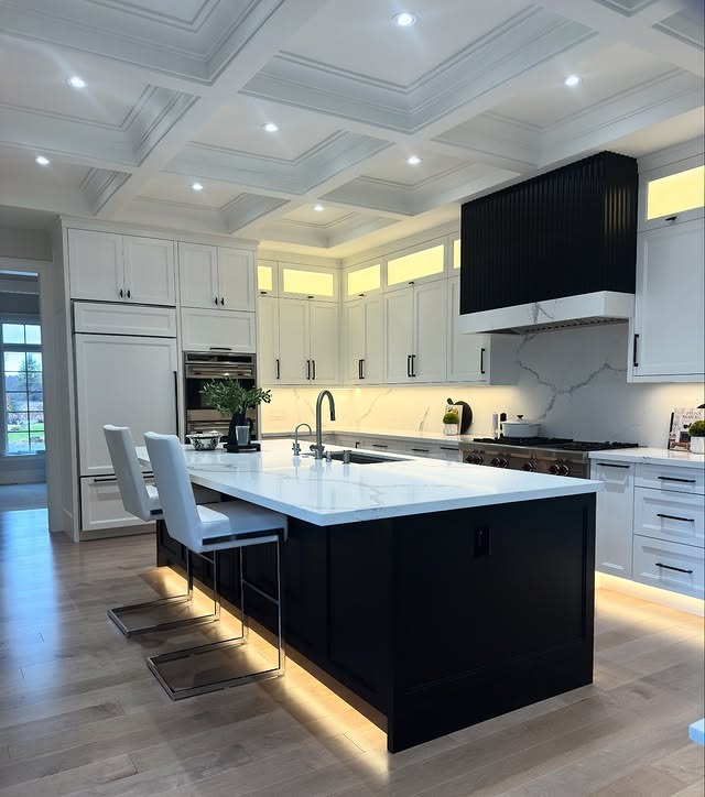 22. Contemporary Kitchen with Black Accent Hood and Illuminated Island Base - black and white kitchen ideas