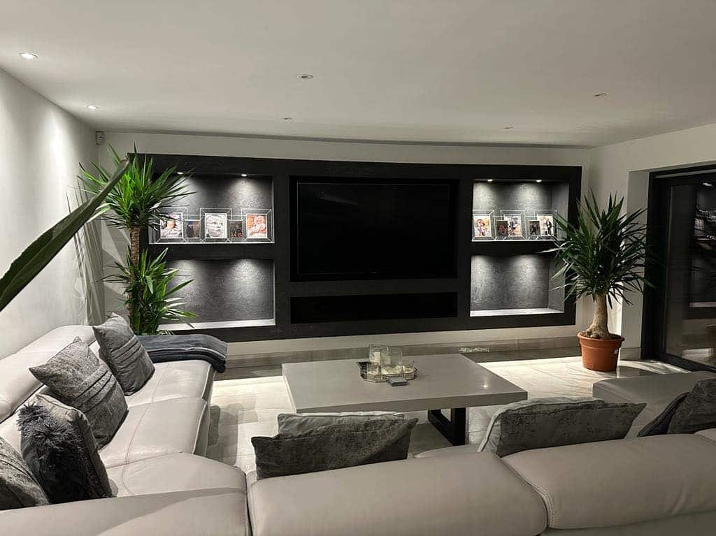 1. Sleek Charcoal Media Wall with Soft Grey Seating - grey and black living room ideas