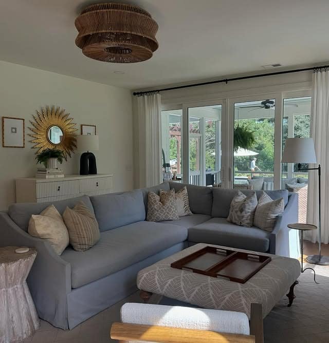 13. Muted Blue Corner Sofa with Natural Light and Woven Textures - blue sofa living room ideas