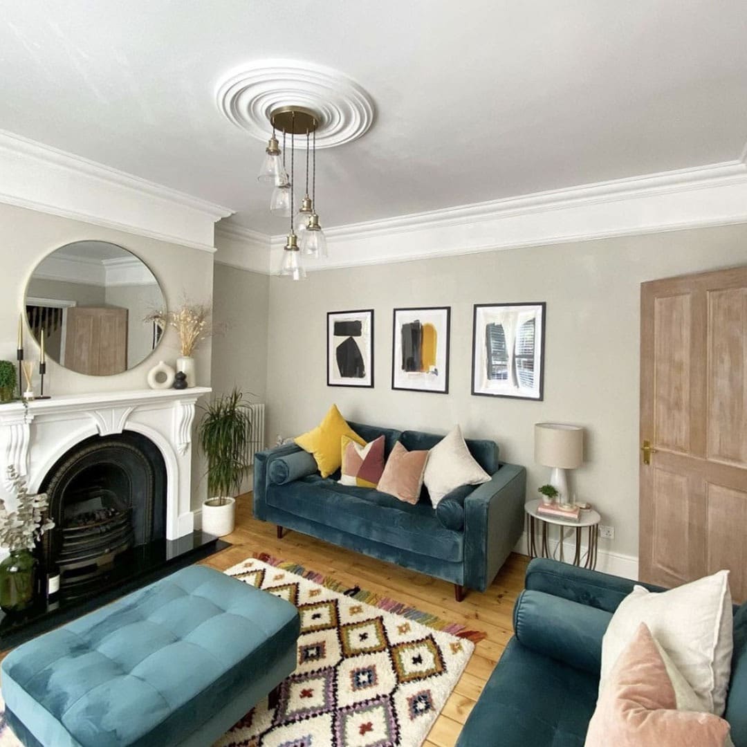 18. Teal Blue Sofa with Warm Wood Floors and Graphic Accents - blue sofa living room ideas