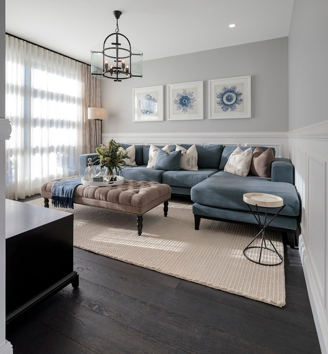 20. Blue Sectional with Elegant Paneling and Soft Neutrals - blue sofa living room ideas