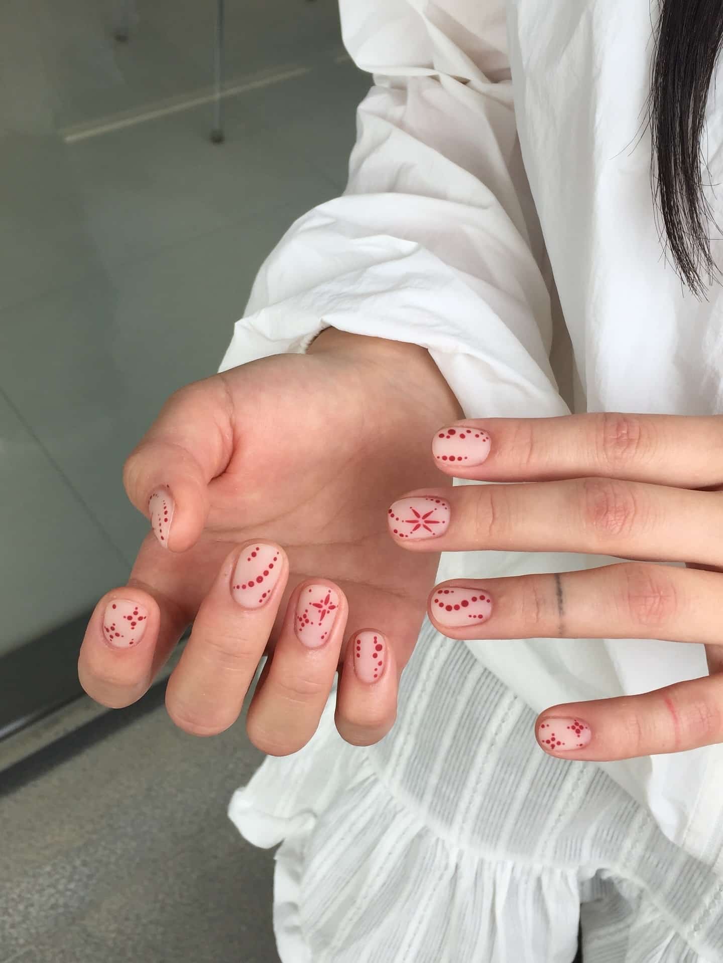 2. Sheer Nude Nails with Red Dot Art - very short nail ideas