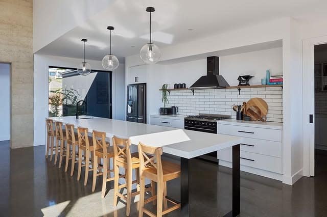5. Minimalist White Kitchen with Extended Island Seating - big kitchen ideas