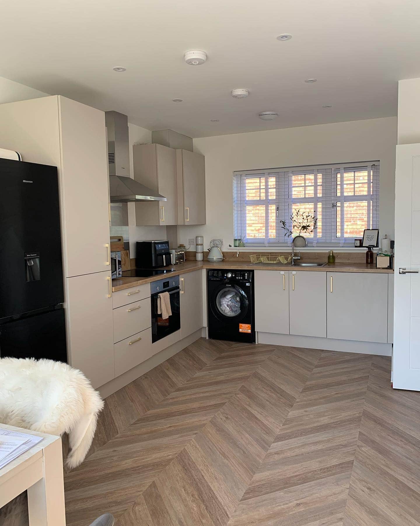 7. Compact Neutral Kitchen with Beige Cabinets and Herringbone Flooring - big kitchen ideas