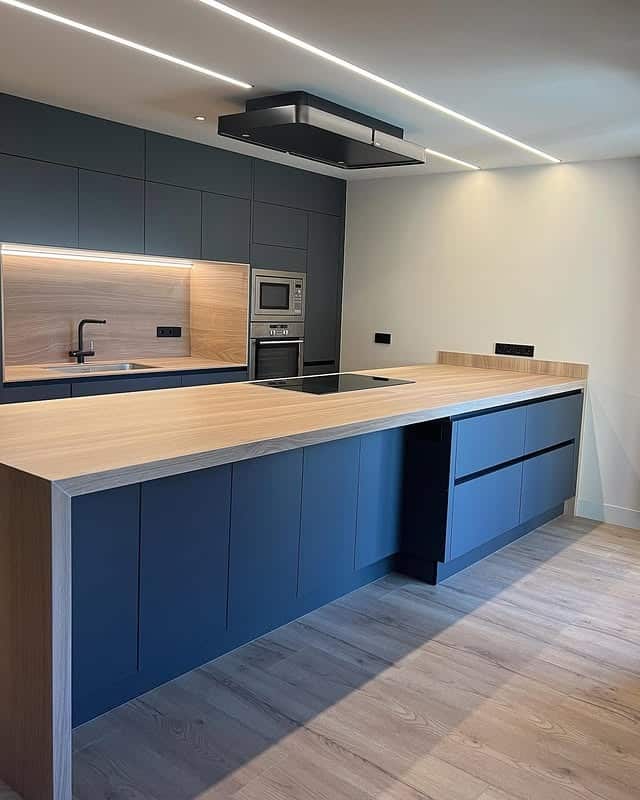 22. Minimalist Blue Kitchen with Seamless Wood Countertops - big kitchen ideas