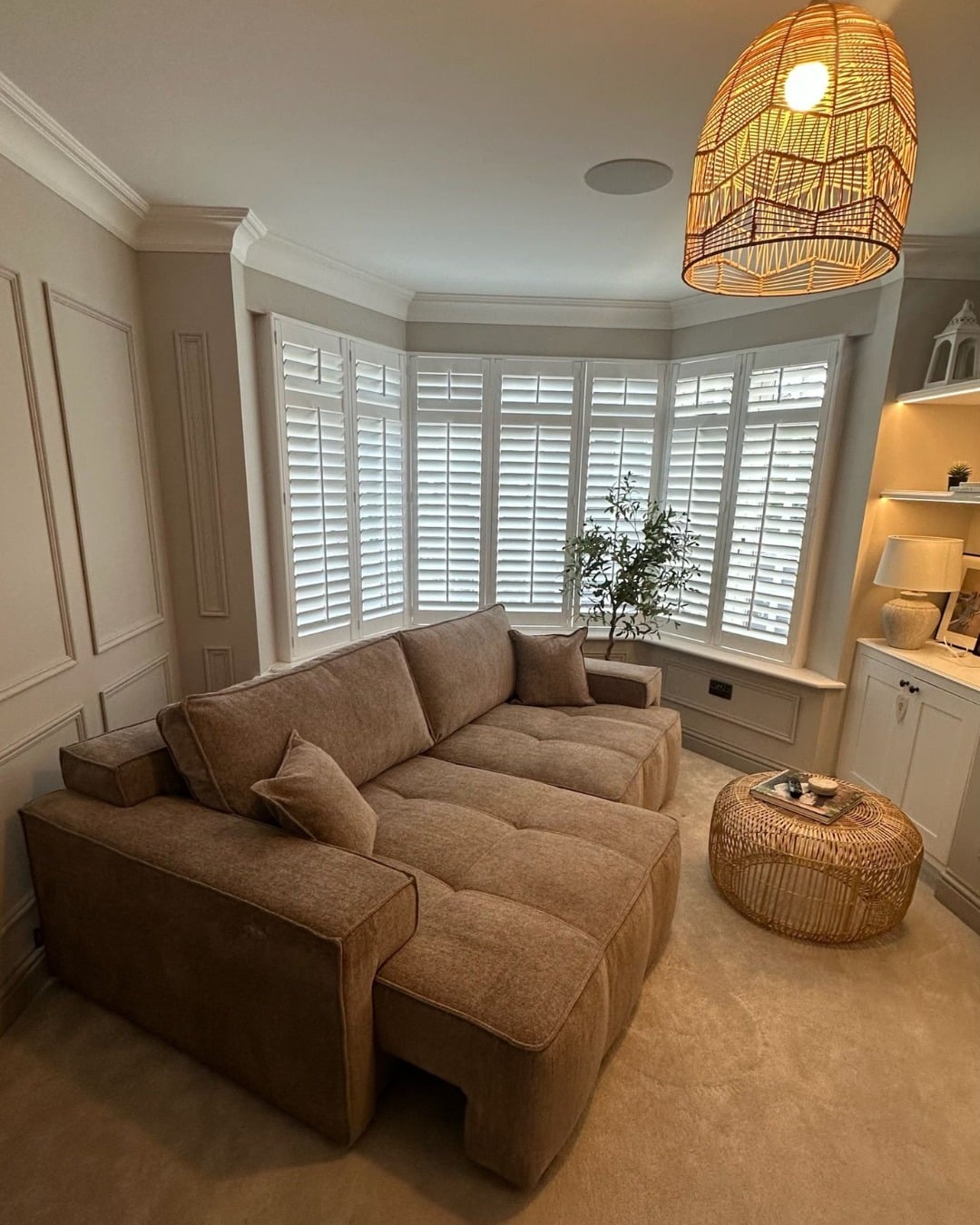 2. Cozy Caramel Brown Sectional with Warm Lighting and Bay Windows - dark brown sofa living room ideas