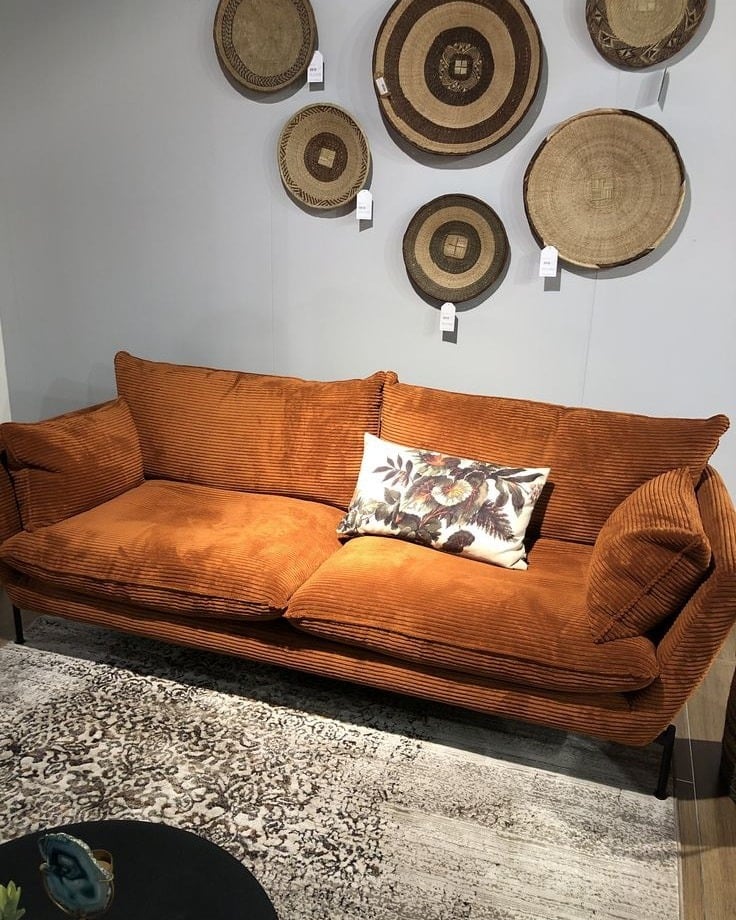 6. Rust-Toned Corduroy Sofa with Textural Wall Decor - dark brown sofa living room ideas