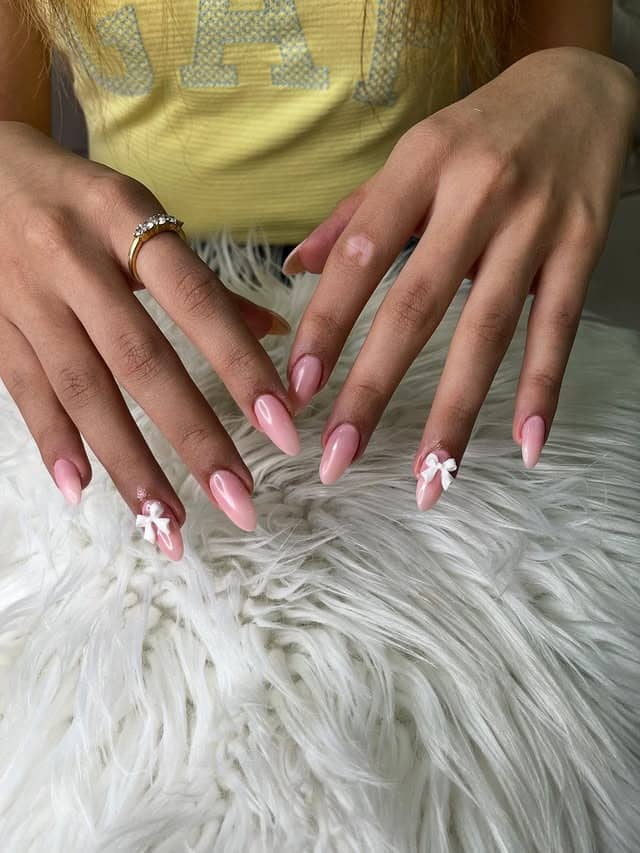 2. Glossy Blush Pink Almond Nails with Minimal Bow Detail - nail ideas with bows