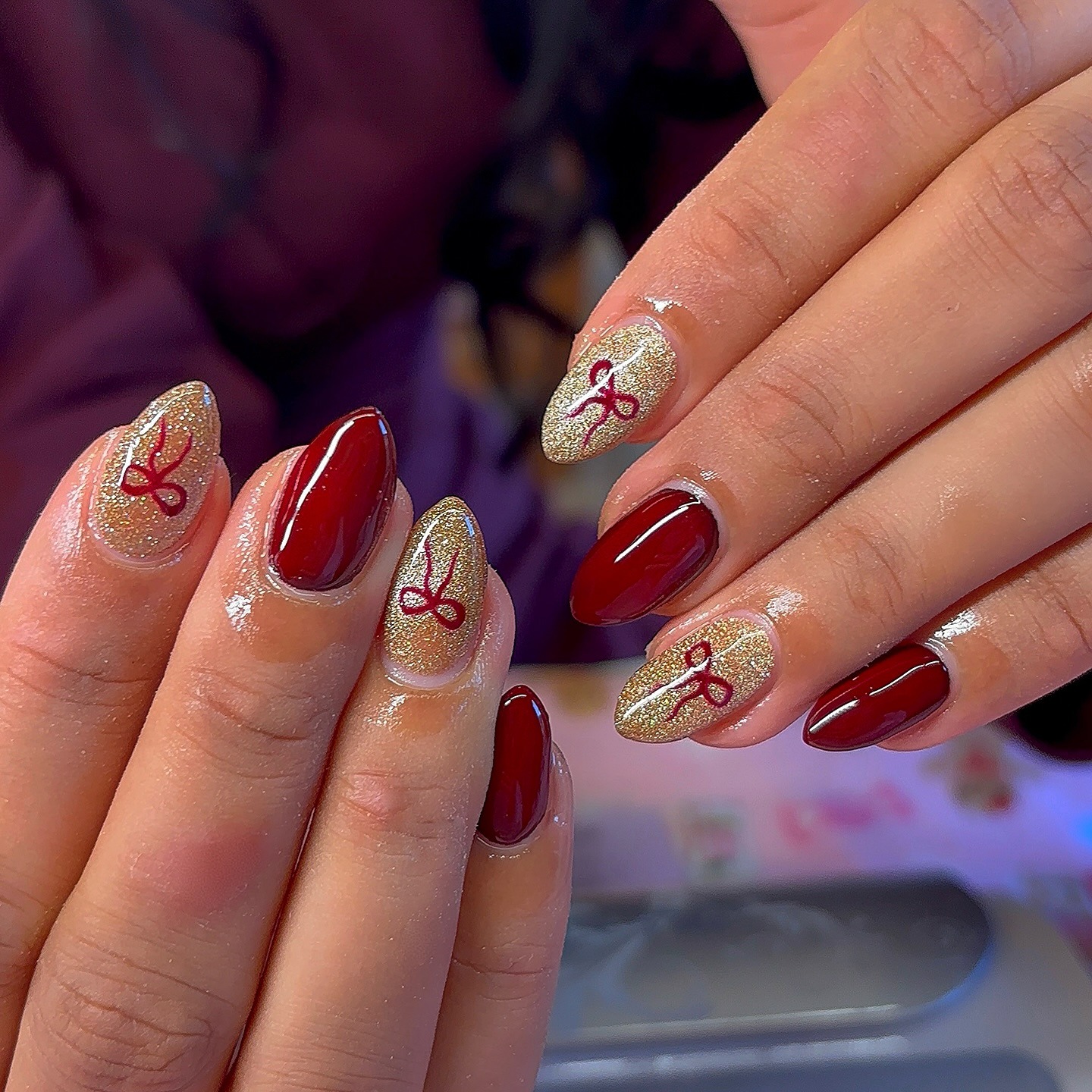 9. Red and Gold Almond Nails with Metallic Bow Motifs - nail ideas with bows
