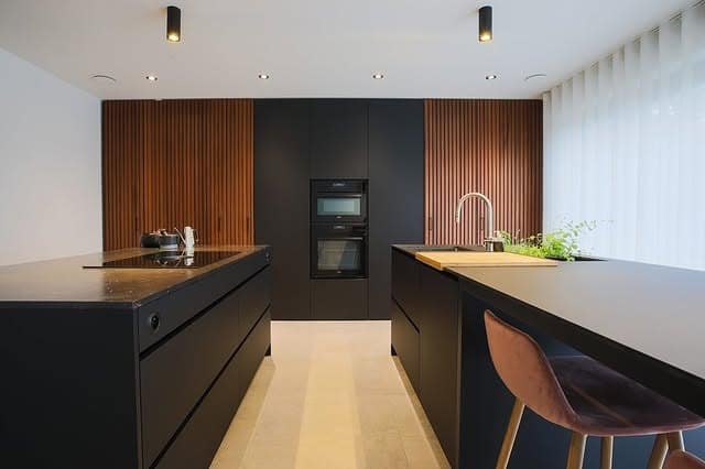 11. Sleek Black Kitchen with Vertical Wood Slat Accent - black and wood kitchen ideas