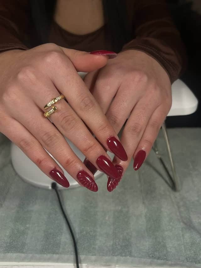 11. Deep Burgundy Almond Nails with Textured Accent Detail - red nail ideas