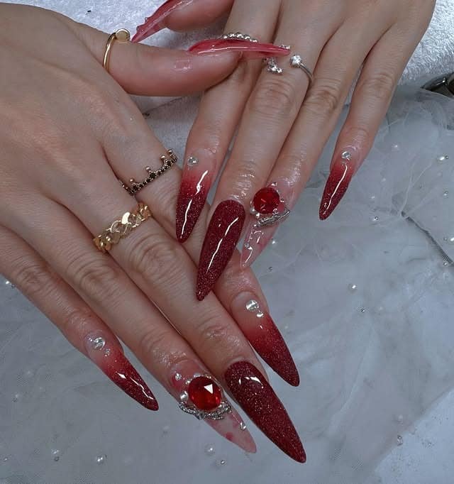 12. Red Glitter Stiletto Nails with Crystal Embellishments - red nail ideas