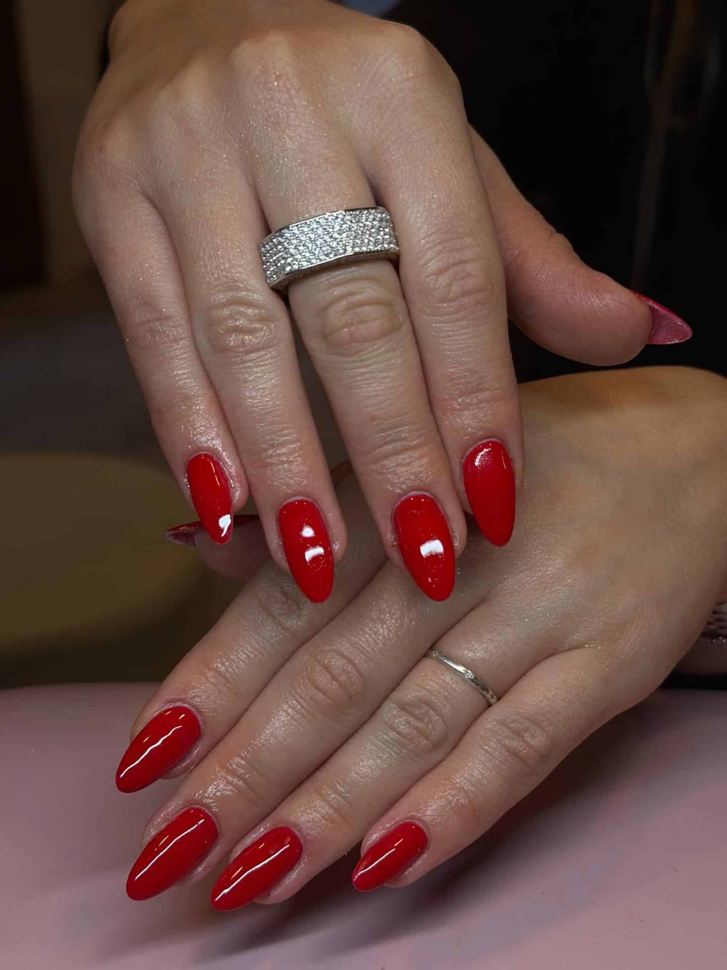 14. Classic Bright Red Almond Nails with Micro Shimmer - red nail ideas