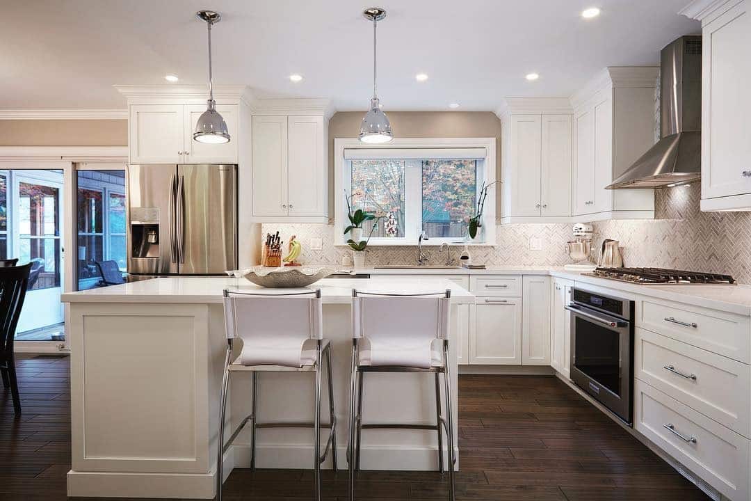 5. Bright Cream Kitchen with Warm Wood Flooring - cream kitchen cabinet ideas