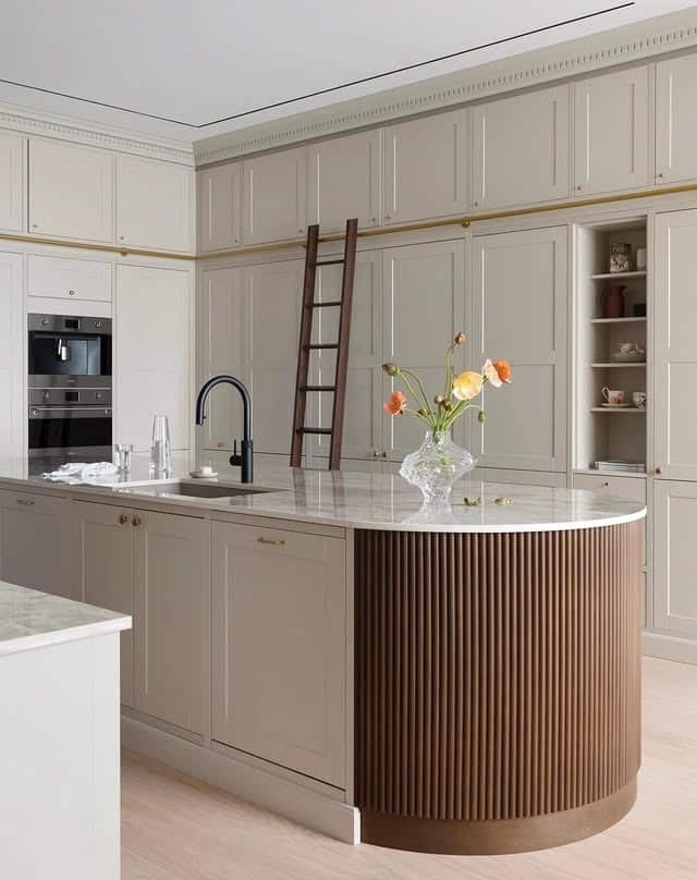 12. Elegant Cream Kitchen with Fluted Wood Island Detail - cream kitchen cabinet ideas