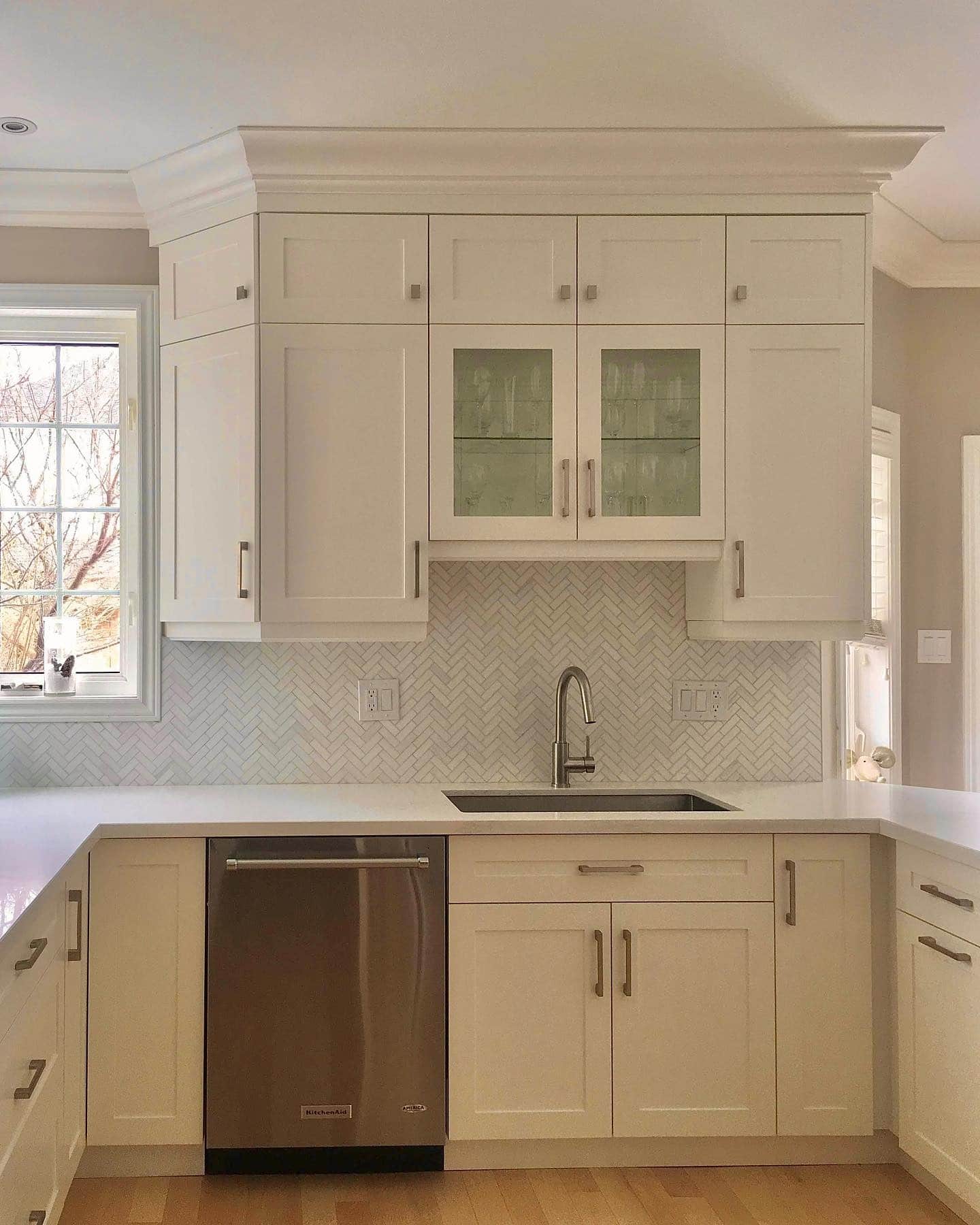 14. Traditional Cream Kitchen with Herringbone Backsplash - cream kitchen cabinet ideas