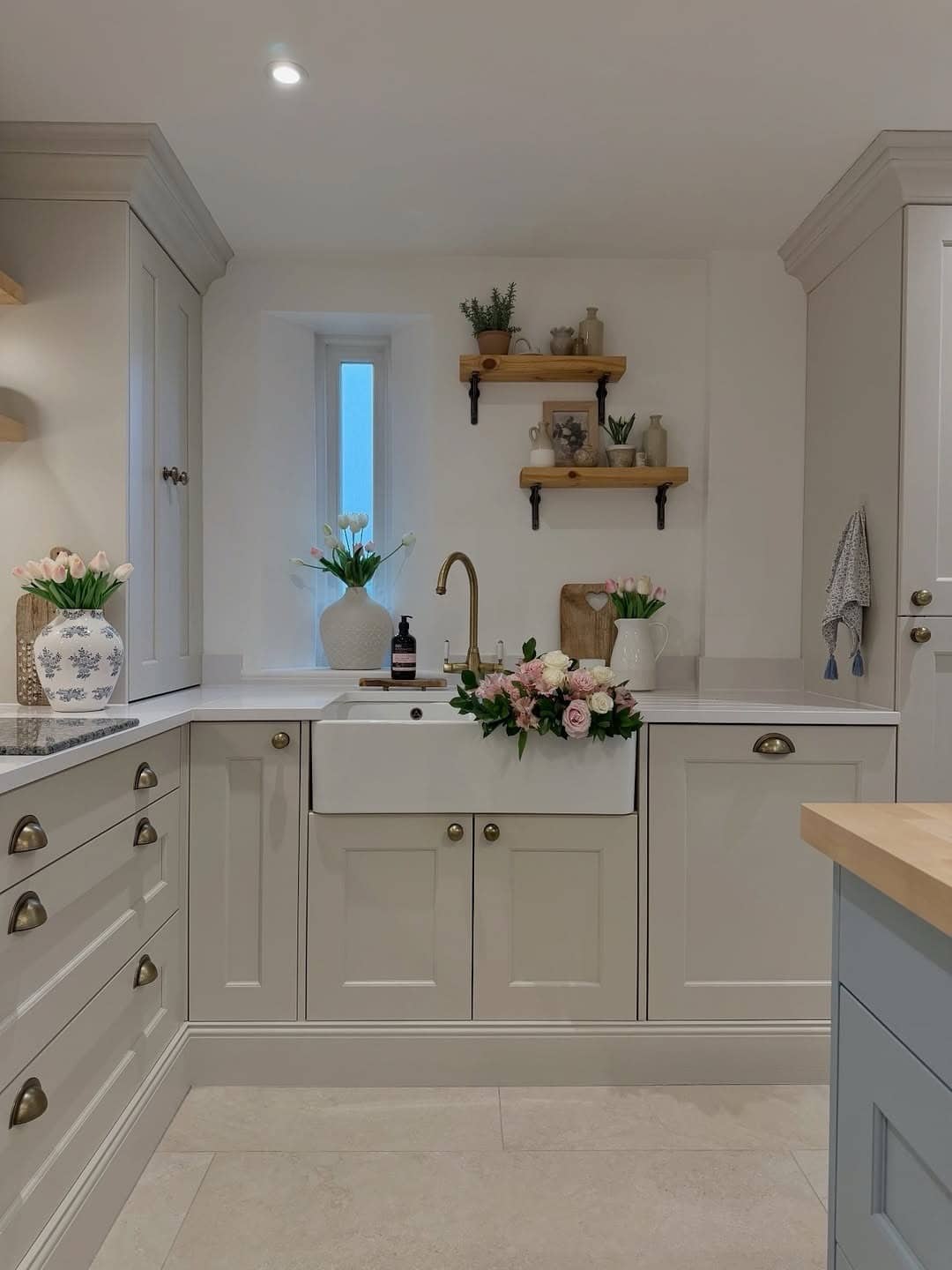 17. Cottage-Inspired Cream Kitchen with Brass Hardware - cream kitchen cabinet ideas