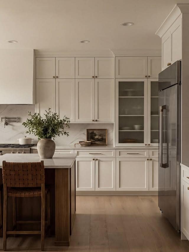 20. Refined Cream Kitchen with Glass-Front Cabinet Accents - cream kitchen cabinet ideas