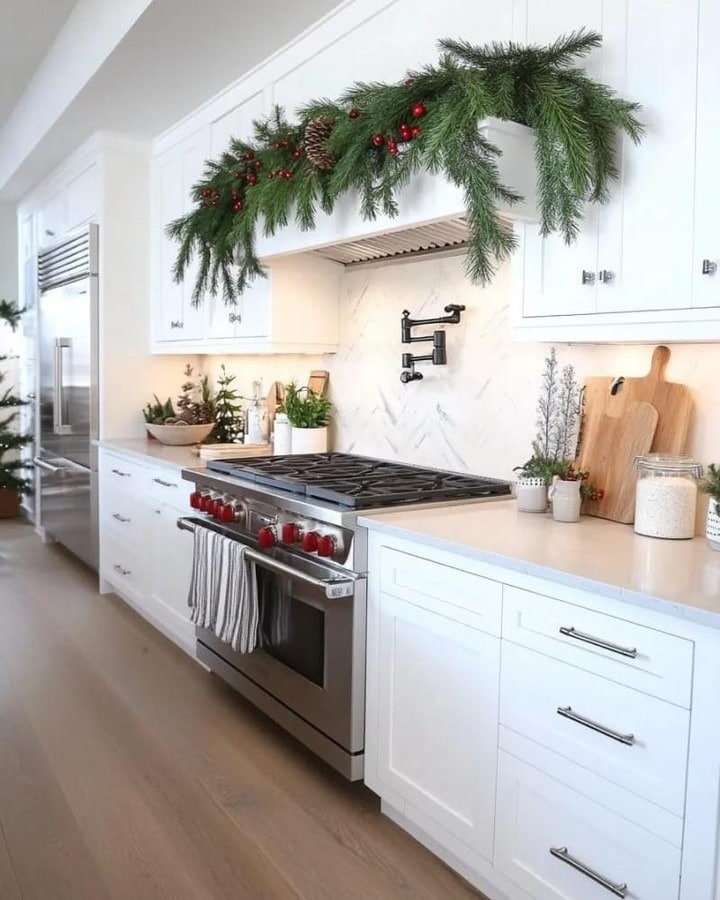 13. Minimal White Kitchen with Fresh Green Garland Detail - christmas decor kitchen ideas