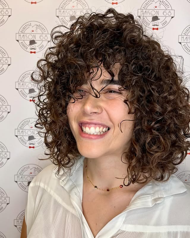 7. Rounded Brunette Curly Wolf Shag - Curly Wolf Haircut