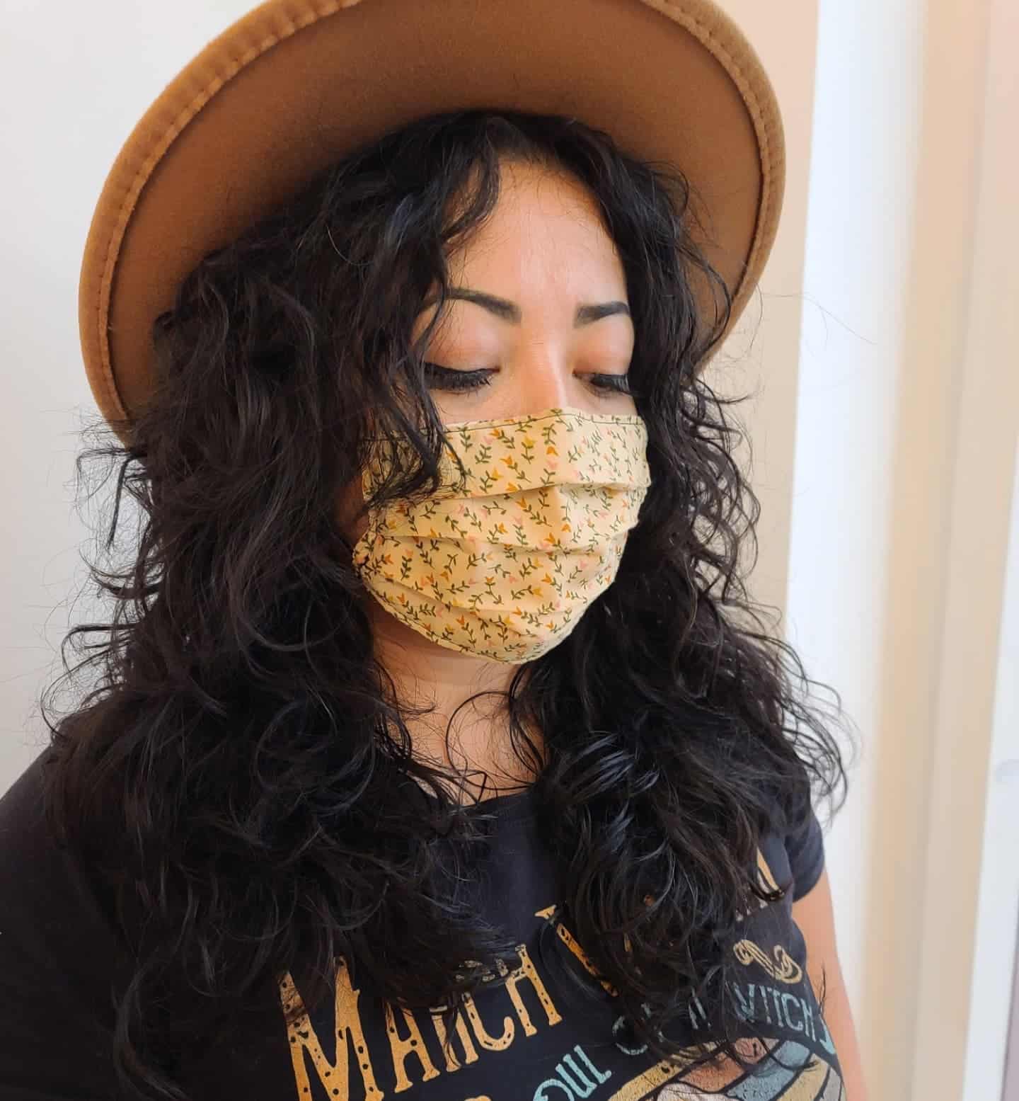 15. Soft Black Curly Wolf Cut with Hat Styling - Curly Wolf Haircut