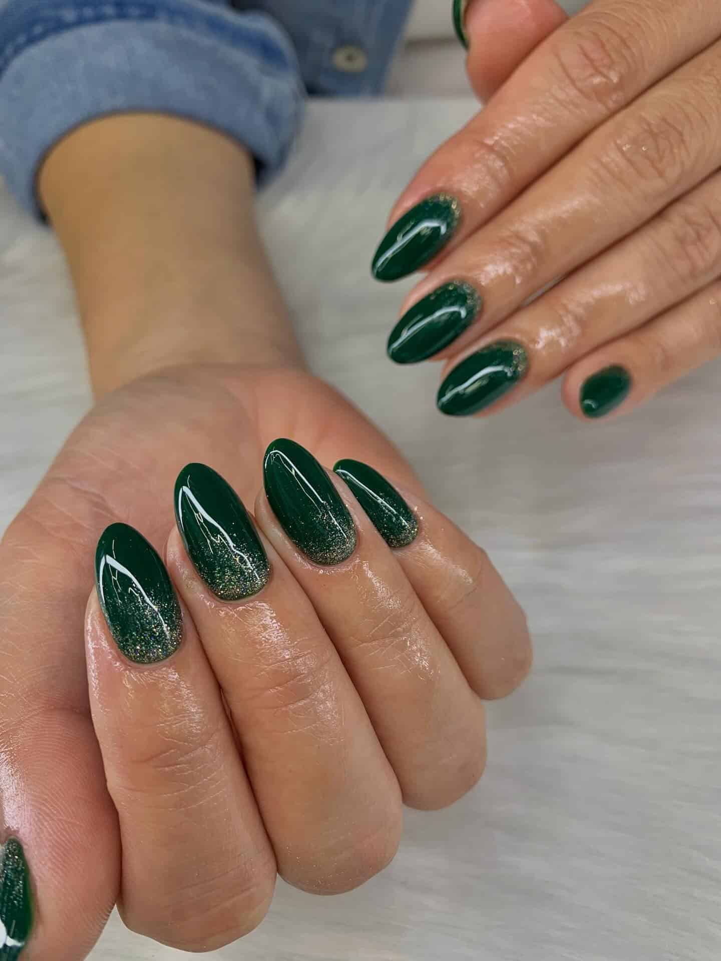 9. Emerald Glitter Fade Almond Nails - green christmas nail ideas