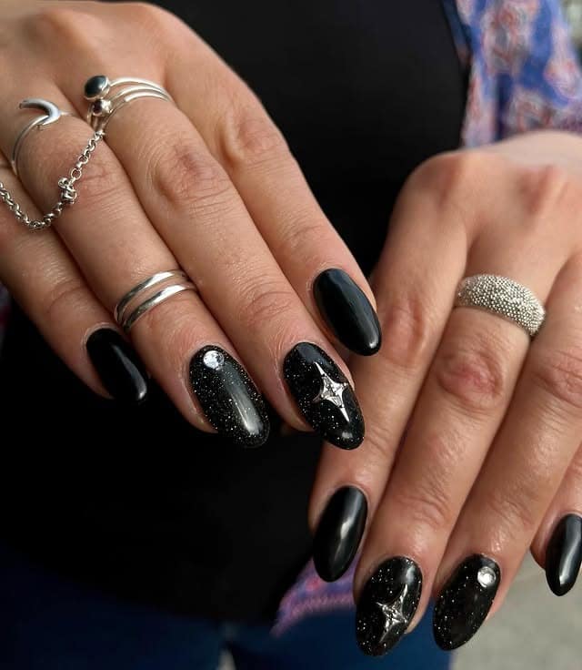 9. Black Cosmic Gloss Nails with Star Accents - black nail ideas