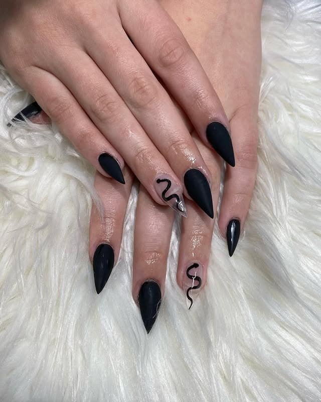 18. Matte Black Stiletto Nails with Snake Accent - black nail ideas