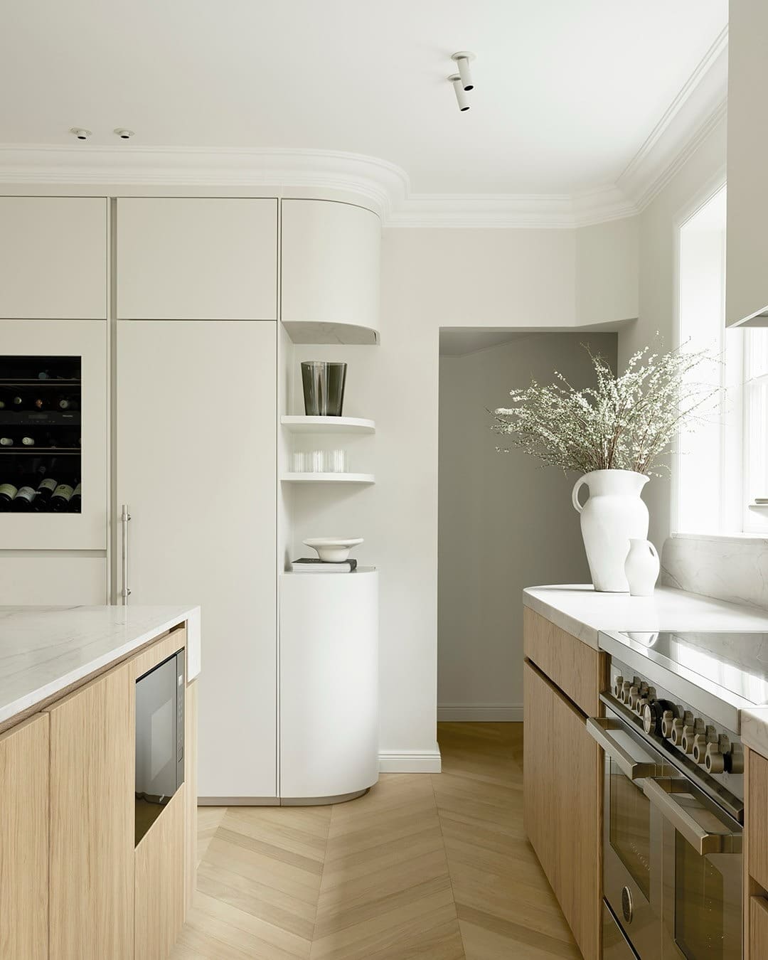 11. Sculpted White Countertop Kitchen with Soft Cream and Light Wood - white countertop kitchen ideas