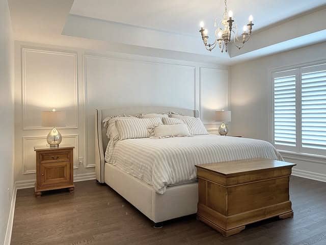 13. Classic White Wall Paneling with Warm Wood Furnishings - white wall bedroom ideas